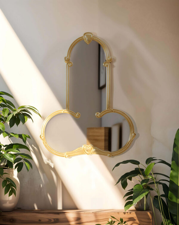Le miroir liberty de la marque Seletti est accroché sur un mur blanc avec des plantes autour.