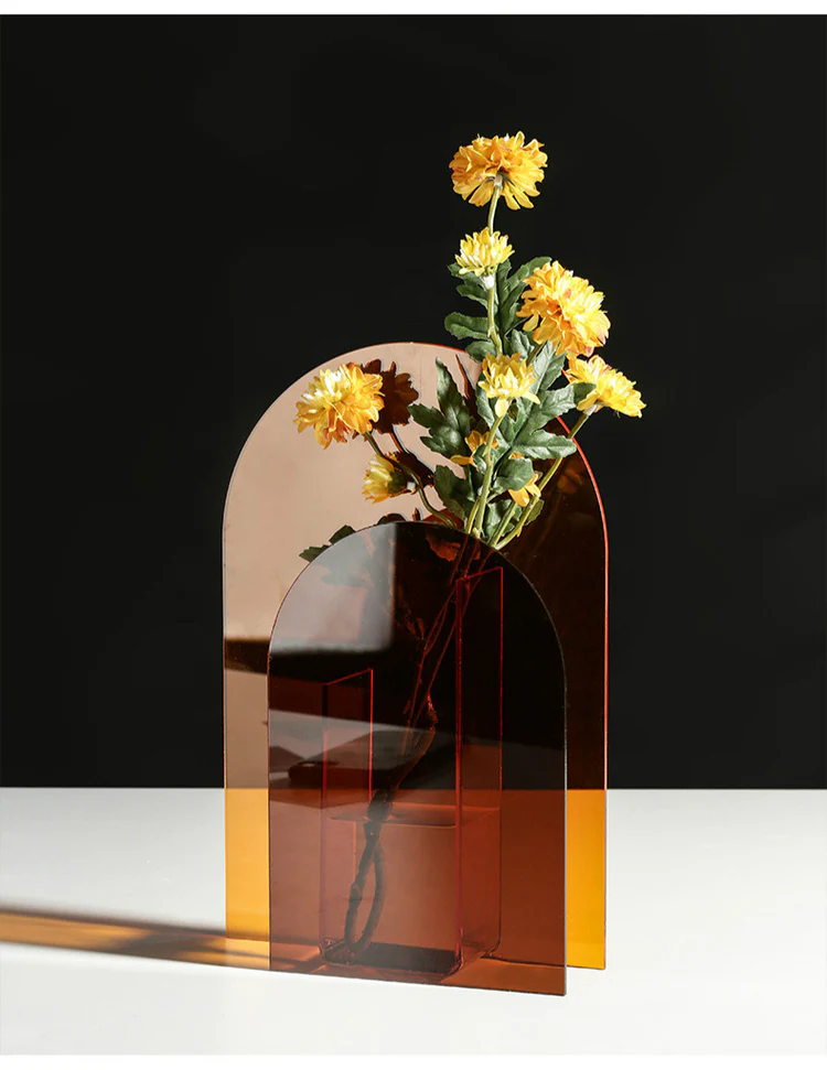 Vase acrylique Ambre et Orange au Design Géométrique Rétro Pavao Studio Photo d'un vase en acrylique bicolore translucide. Composé d'une grande arche orange et d'une petite arche en U de couleur ambre foncé. Style design minimaliste.
