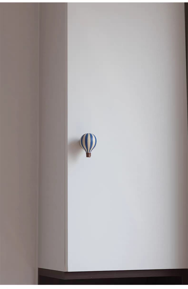 Patère montgolfière — rouge, jaune, bleu en résine Patère murale montgolfière bleu sur un mur blanc