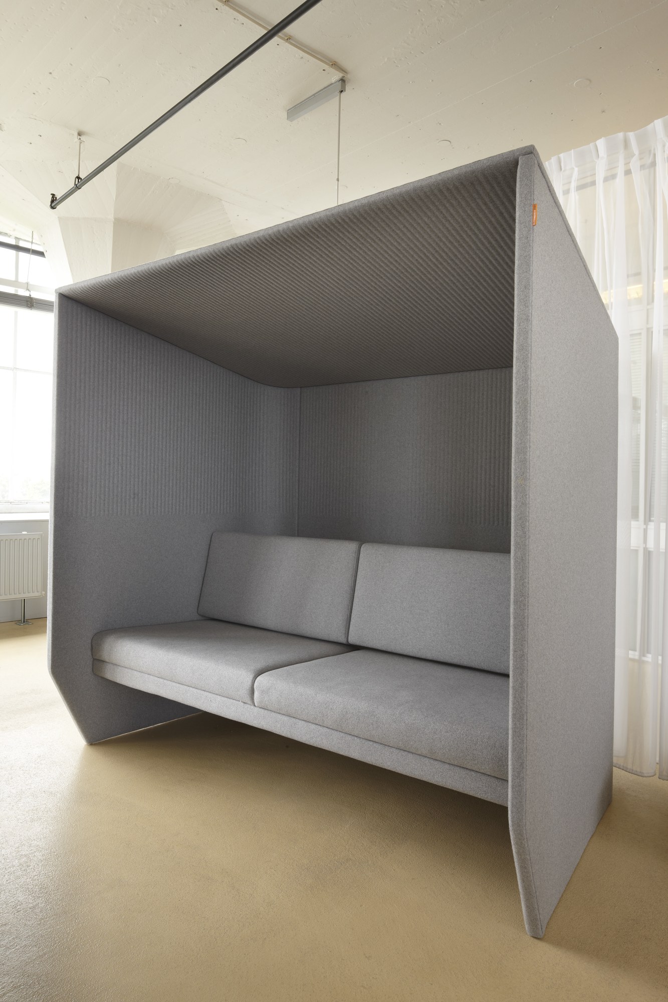 Alcôve acoustique BuzziHub par BuzziSpace, simple ou double alcôve acoustique BuzziHub BuzziSpace grise avec banquette en tissu
