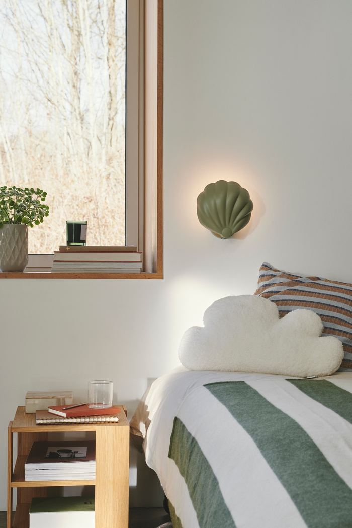 Luminaire chambre enfant ou ado : comment bien le choisir ? Applique chambre enfant en forme de coquillage Nordlux Konchi au-dessus d'un lit