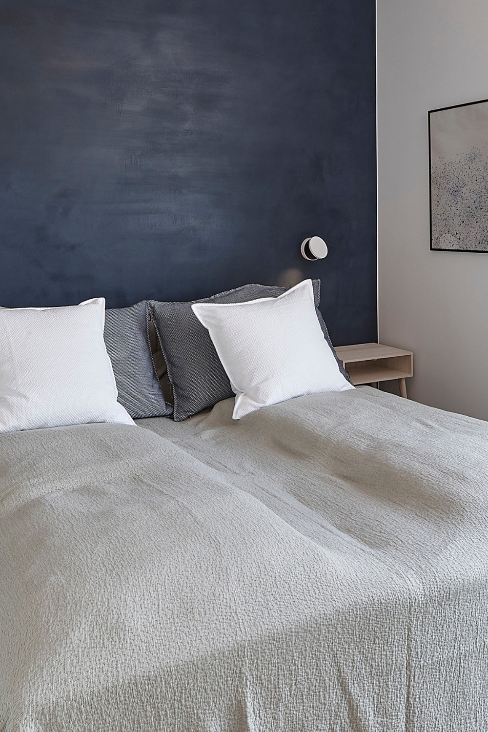 applique Dot Wall W120 Antidark blanche au-dessus d'une tête de lit dans une chambre