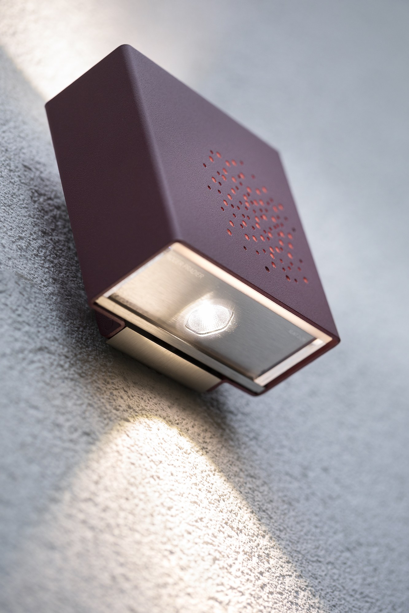 Applique extérieure Klint LED up and down par Roger Pradier applique extérieure Klint face perforée rouge vin, gros plan sur le faisceau du bas