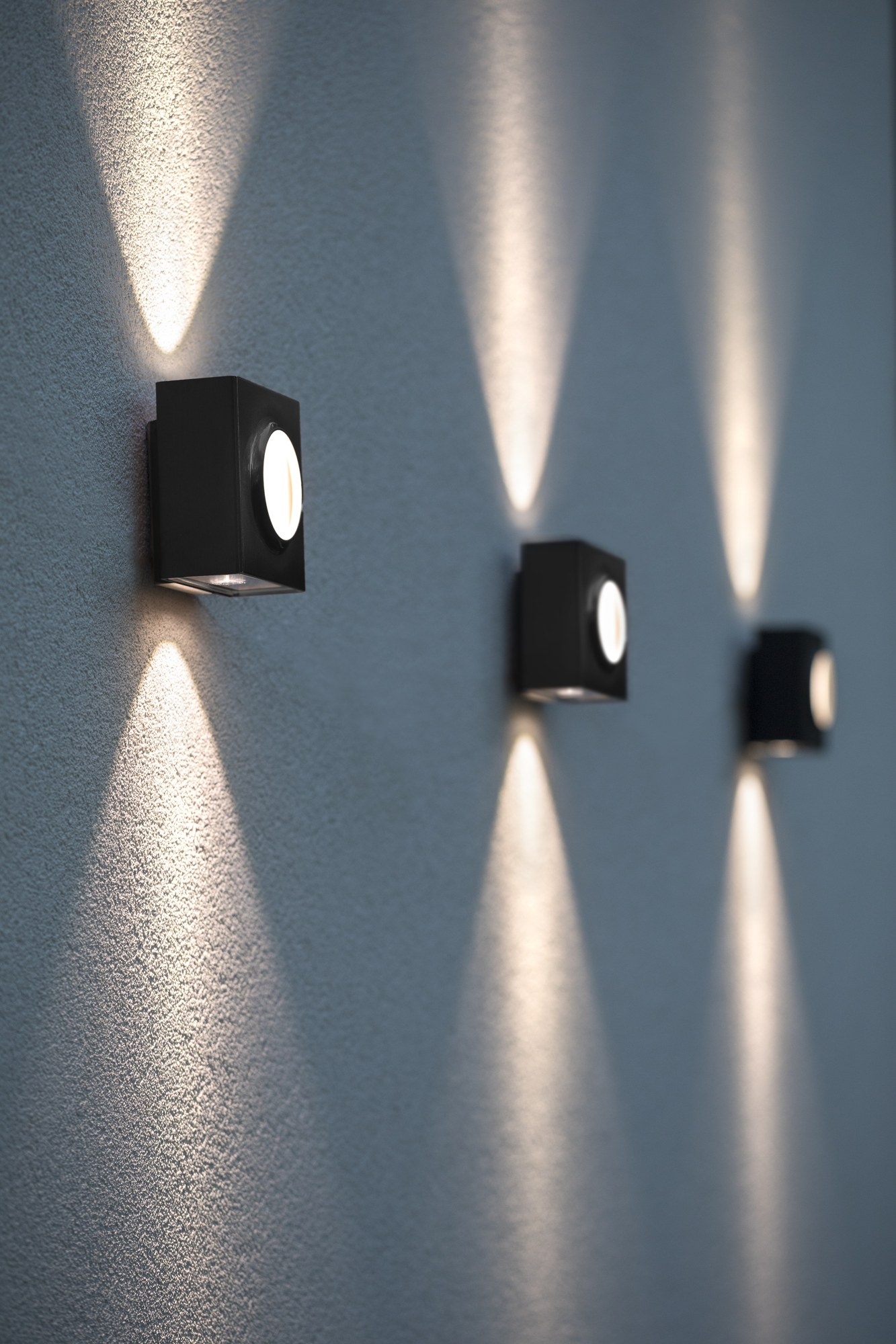 Applique extérieure Klint LED up and down par Roger Pradier applique extérieure Klint, trois cubes en noir velours étagés sur une façade avec cônes de lumière