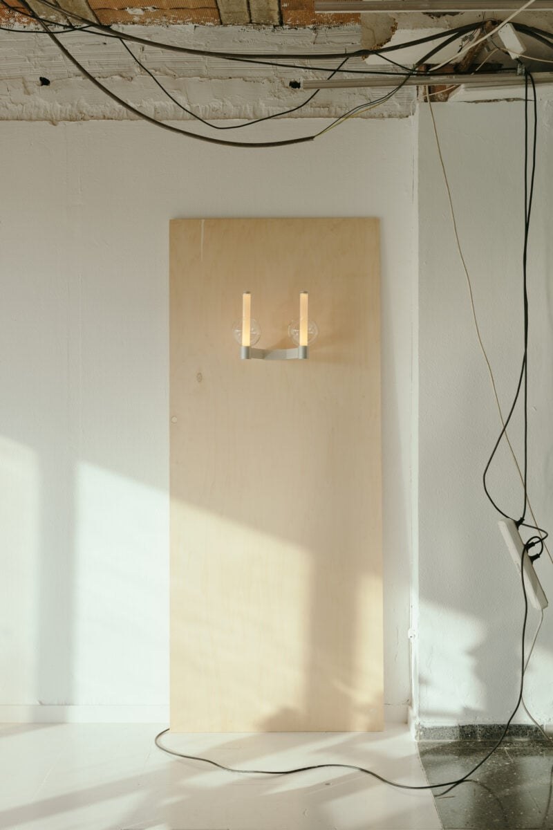 Applique Fragile sphère Marset, A2 allumée sur un panneau de bois clair