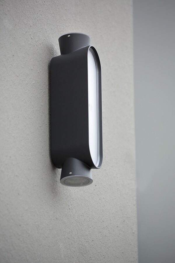 applique LED Ibuk en aluminium noir velours, gros plan sur un mur en crépi gris
