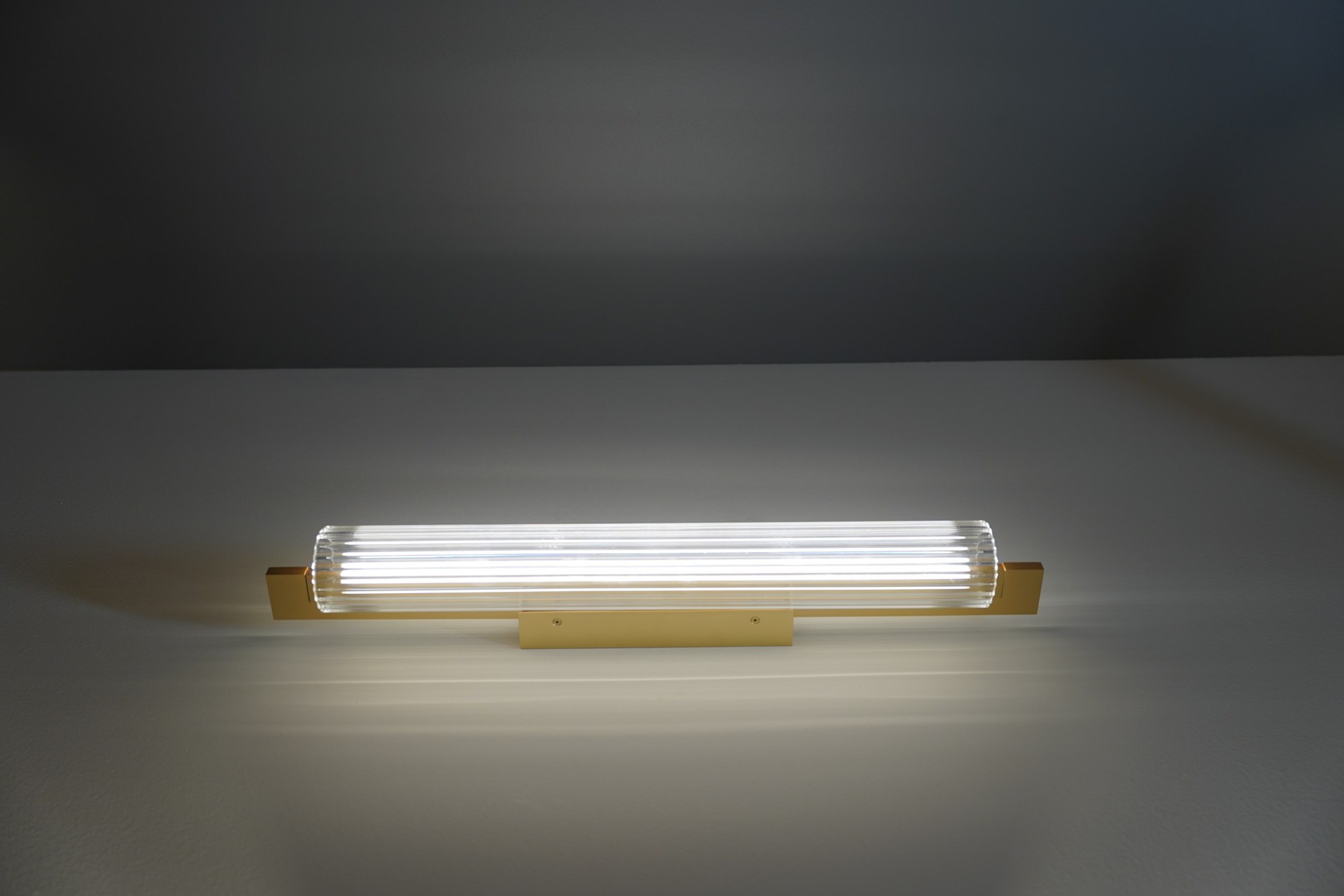 Applique Lirra LED en verre côtelé par Antidark Applique Lirra LED 70 cm allumée, finition laiton