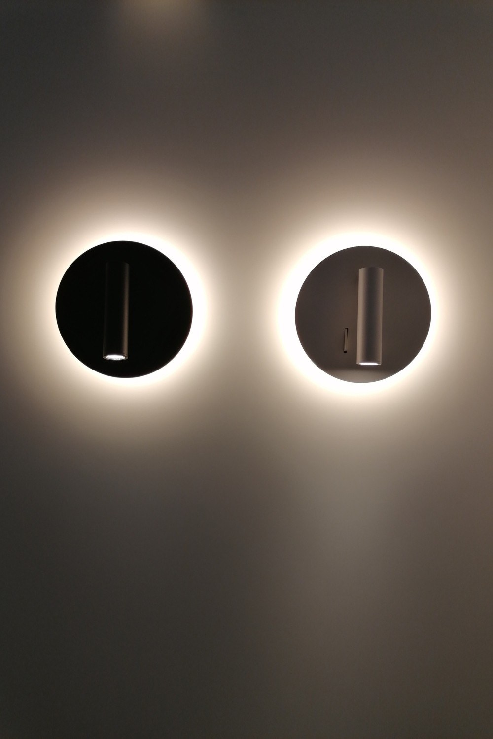 Applique liseuse Circle Wall LED en aluminium par Antidark deux appliques liseuses Circle Wall Antidark allumées avec halo sur le mur