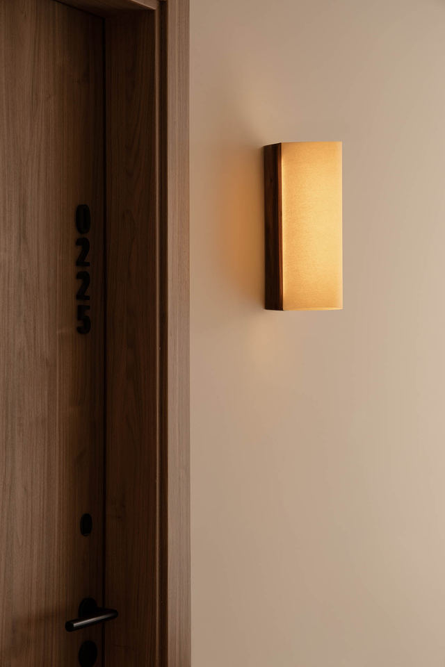 Luminaire entrée et couloir : comment bien l'éclairer ? Applique murale Cata en noyer et papyrus près d'une porte