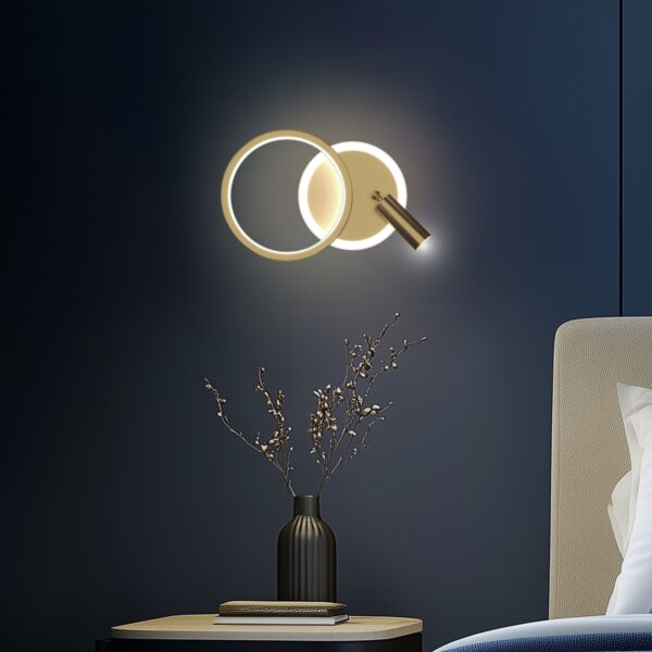 applique murale LED dorée allumée au dessus d une table de chevet sur un mur bleu nuit