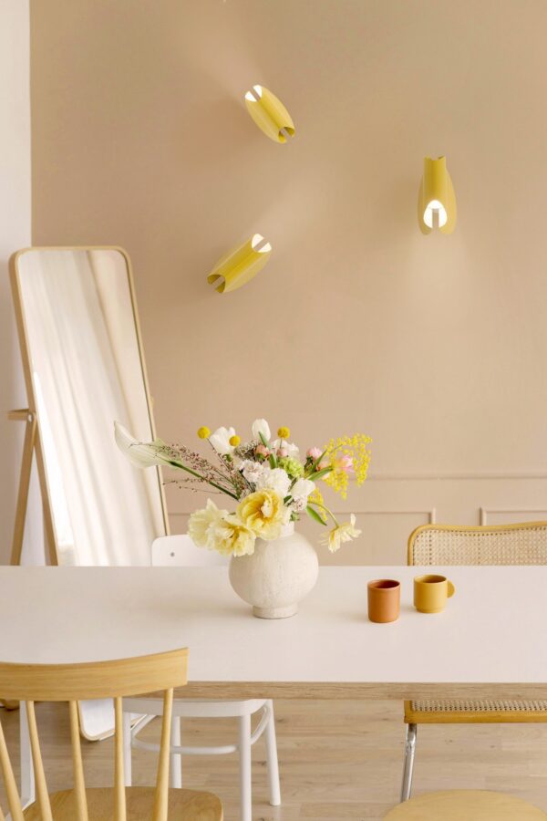 applique Oplà Wall OliveLab, en situation, trois appliques jaunes orientées différemment sur un mur beige