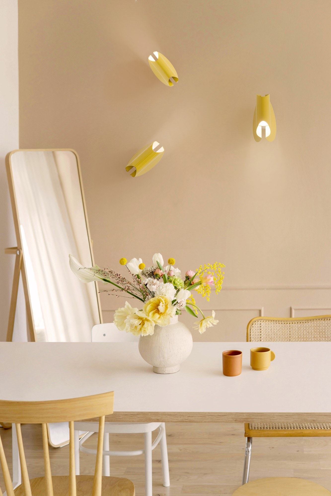 Applique Oplà Wall par OliveLab, acier orientable, 10 finitions applique Oplà Wall OliveLab, en situation, trois appliques jaunes orientées différemment sur un mur beige