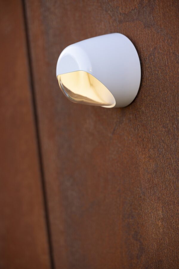 applique Ronex blanche allumee sur un mur en acier rouille