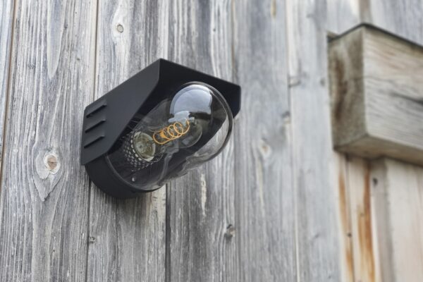 applique RP195 noir velours avec ampoule à filament sur un mur de planches grisées