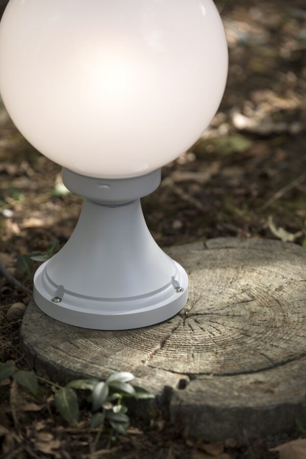borne Moon globe 200 mm teinte blanche avec globe opale posée sur une souche de bois dans un sous-bois