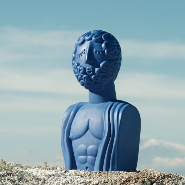Comment Adopter la Tendance Déco Pop : L'Univers de la Marque Seletti buste romain décoratif, buste bleu posé sur un rocher face au ciel