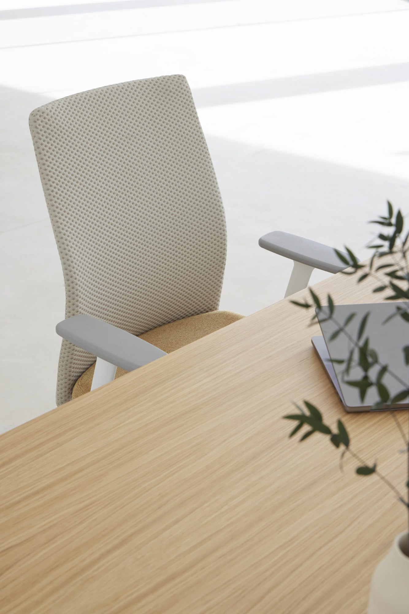Chaise ergonomique Esitt par Inclass, dossier résille ou tapissé chaise ergonomique Inclass Esitt à accoudoirs réglables devant une table en chêne