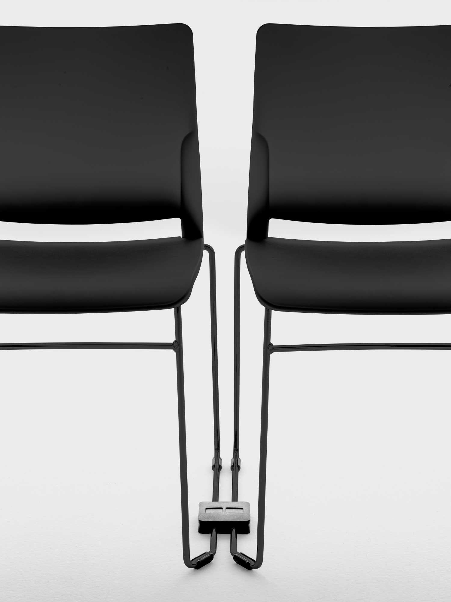 Chaise empilable Area par Bralco, piètement luge, résille ou garnie chaises empilables Area Bralco noires côte à côte, détail du crochet de liaison entre les piètements luge