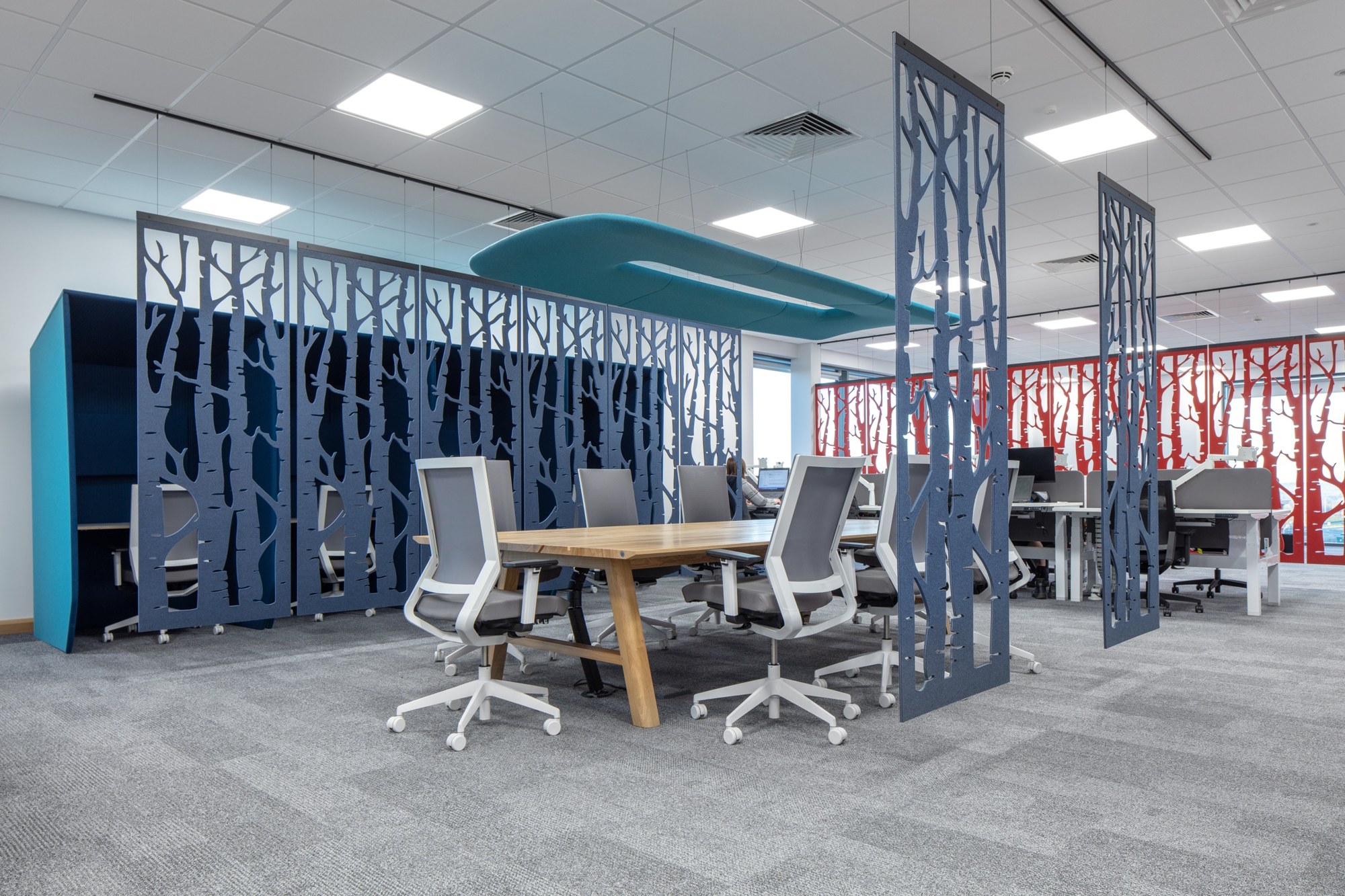 Cloison suspendue BuzziFalls par BuzziSpace, feutre à motifs découpés cloison suspendue BuzziFalls au motif Birch autour d une table de réunion en open space