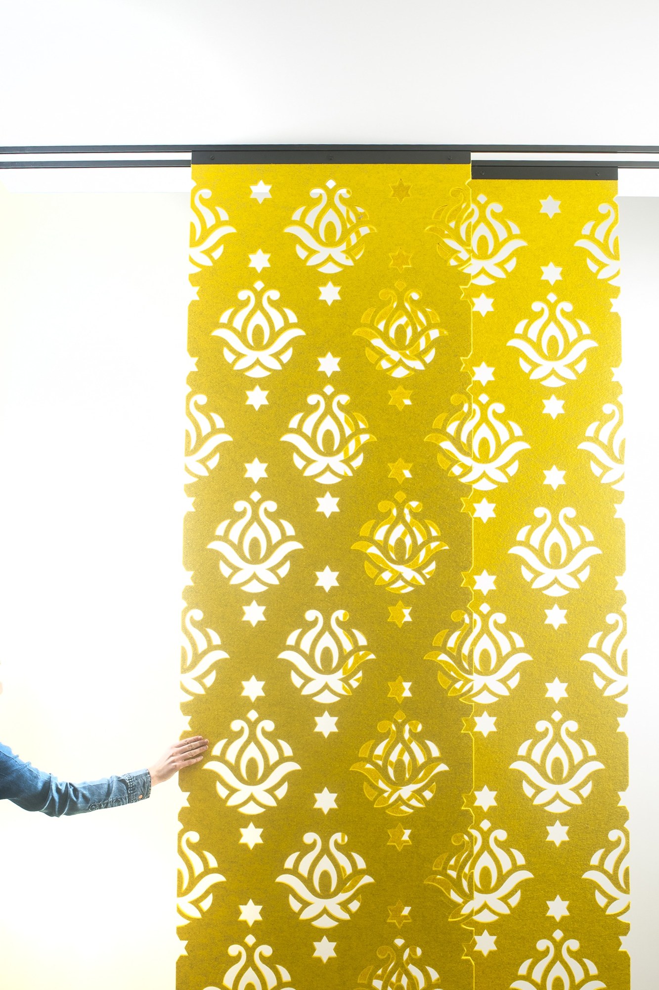 Cloison suspendue BuzziFalls par BuzziSpace, feutre à motifs découpés cloison suspendue BuzziFalls en feutre jaune au motif Royal, panneaux coulissants