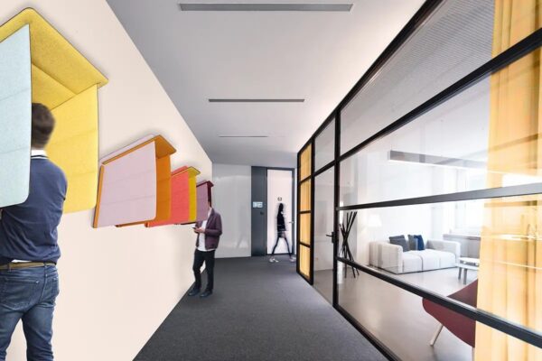 coque acoustique bureau Slalom ECObooth fixée au mur dans un couloir de bureaux