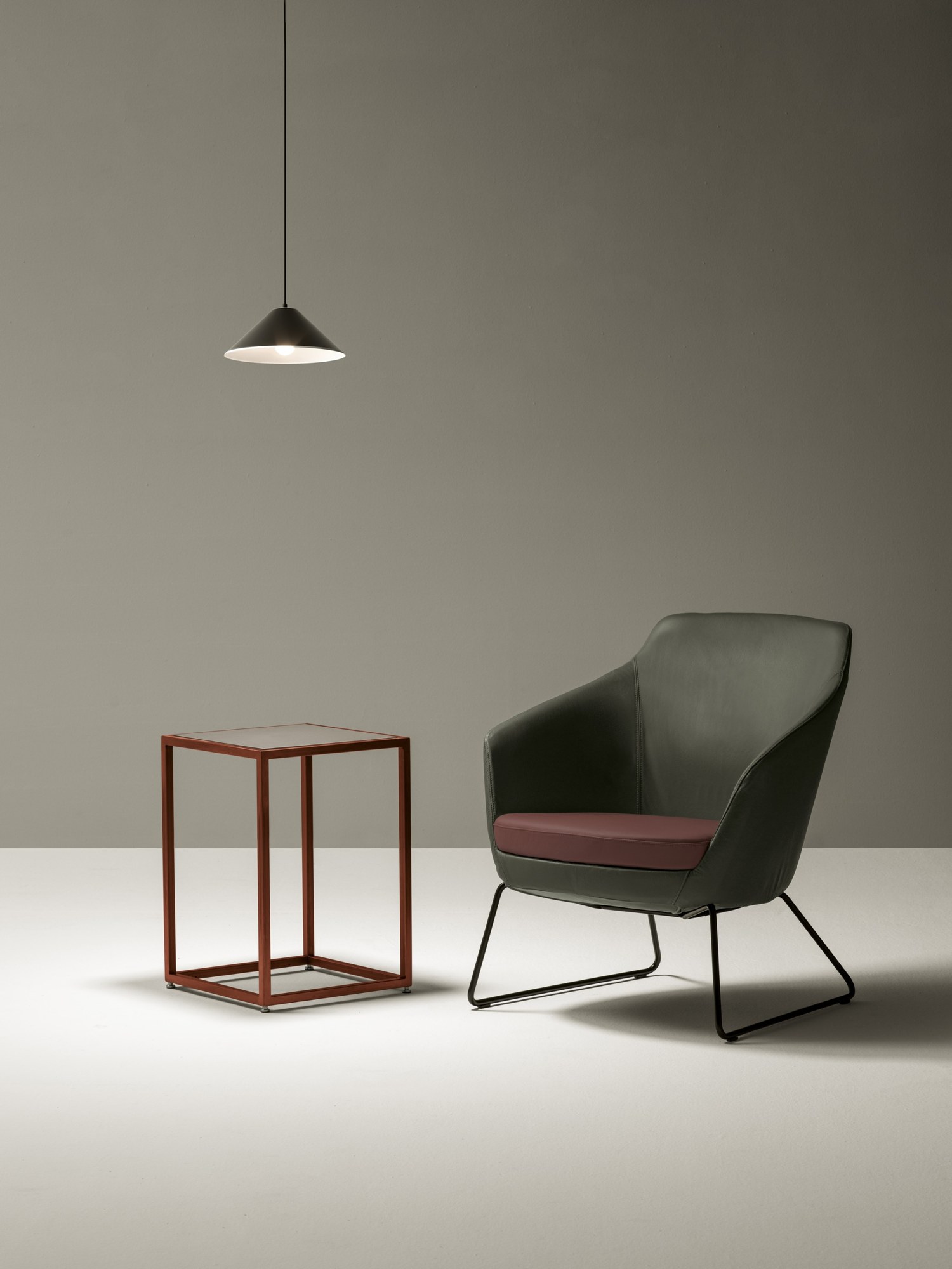 Fauteuil d'accueil Setar par Bralco, canapé 2 places, luge ou pieds bois fauteuil Setar Bralco en cuir vert et assise bordeaux sur luge noire, avec une suspension et un guéridon