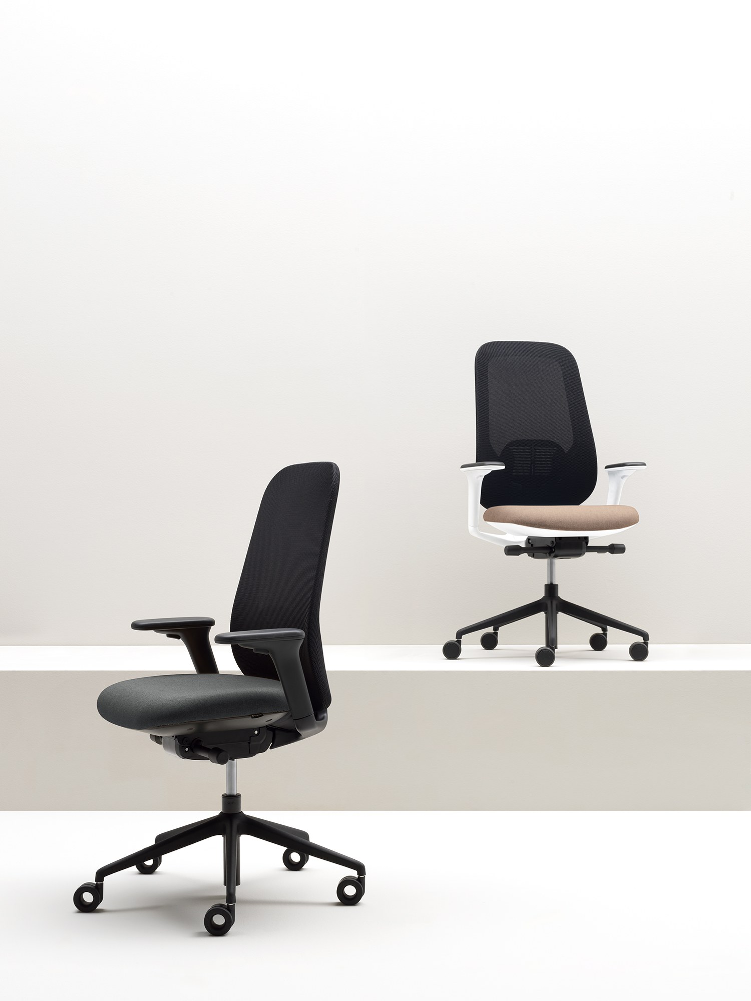 Fauteuil ergonomique Hug en résille à accoudoirs 4D par Bralco fauteuil ergonomique Hug Bralco en ambiance de bureau, structures noire et blanche