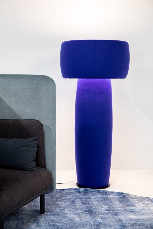 lampadaire acoustique BuzziShroom bleu allumé près d un fauteuil