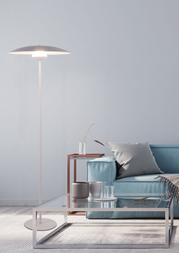 lampadaire LED blanc à disque dans un salon avec canapé bleu