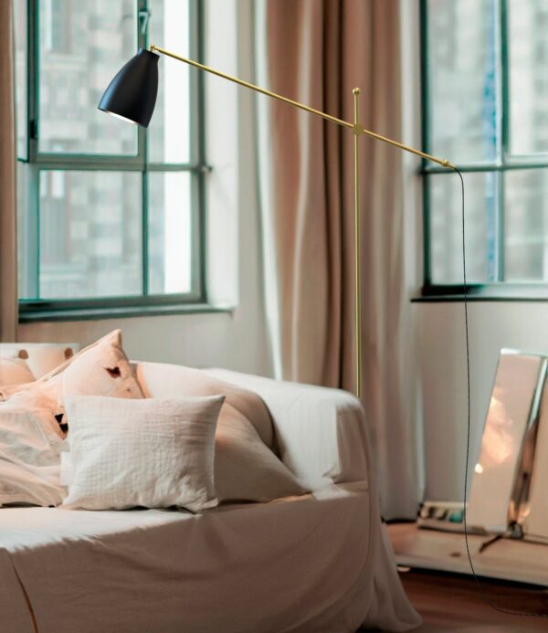 lampadaire Nala dans un salon lumineux, bras mobile déployé au-dessus du canapé