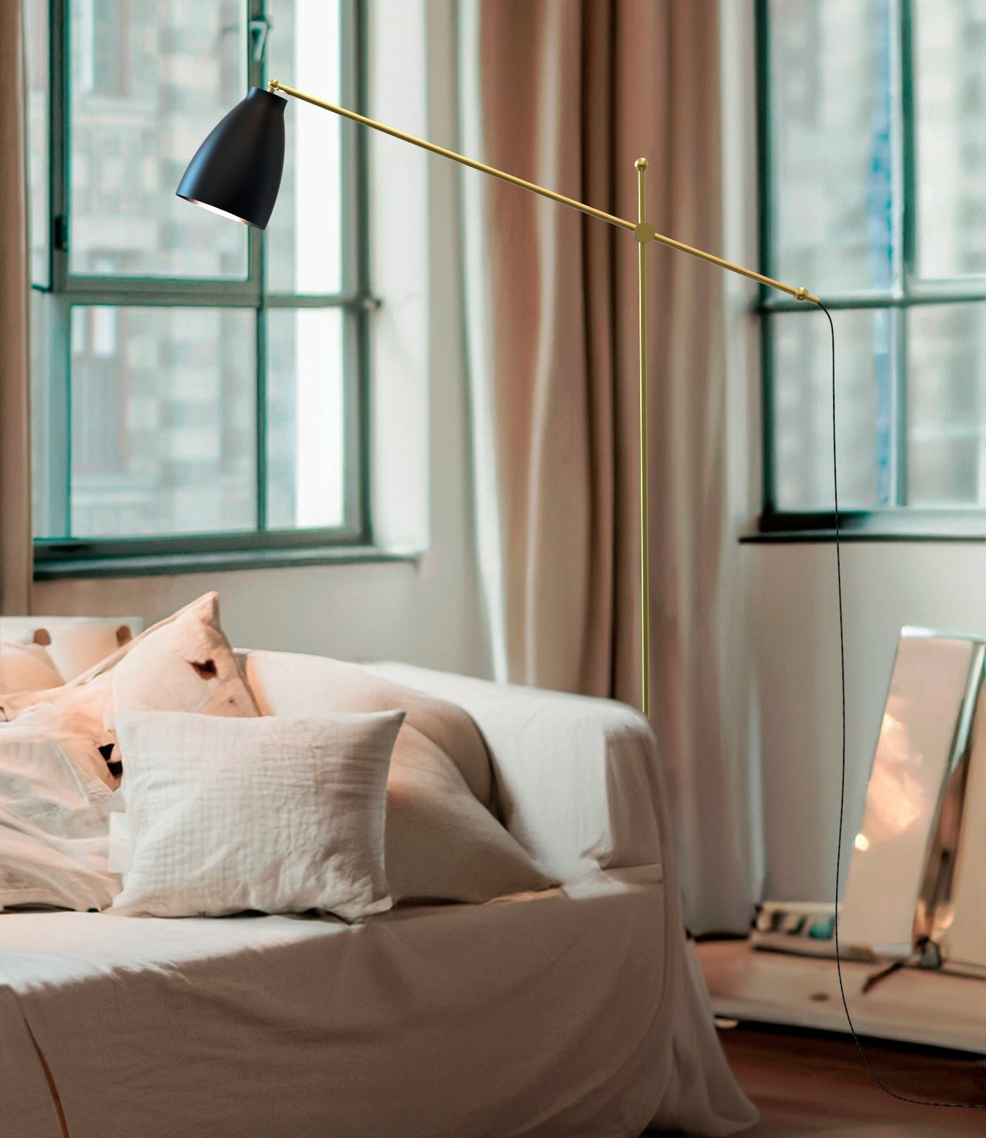 lampadaire Nala dans un salon lumineux, bras mobile déployé au-dessus du canapé