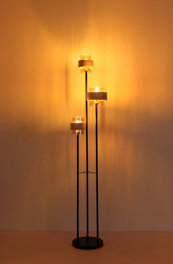 lampadaire travertin 3 lumières allumé, lumière dorée sur le mur