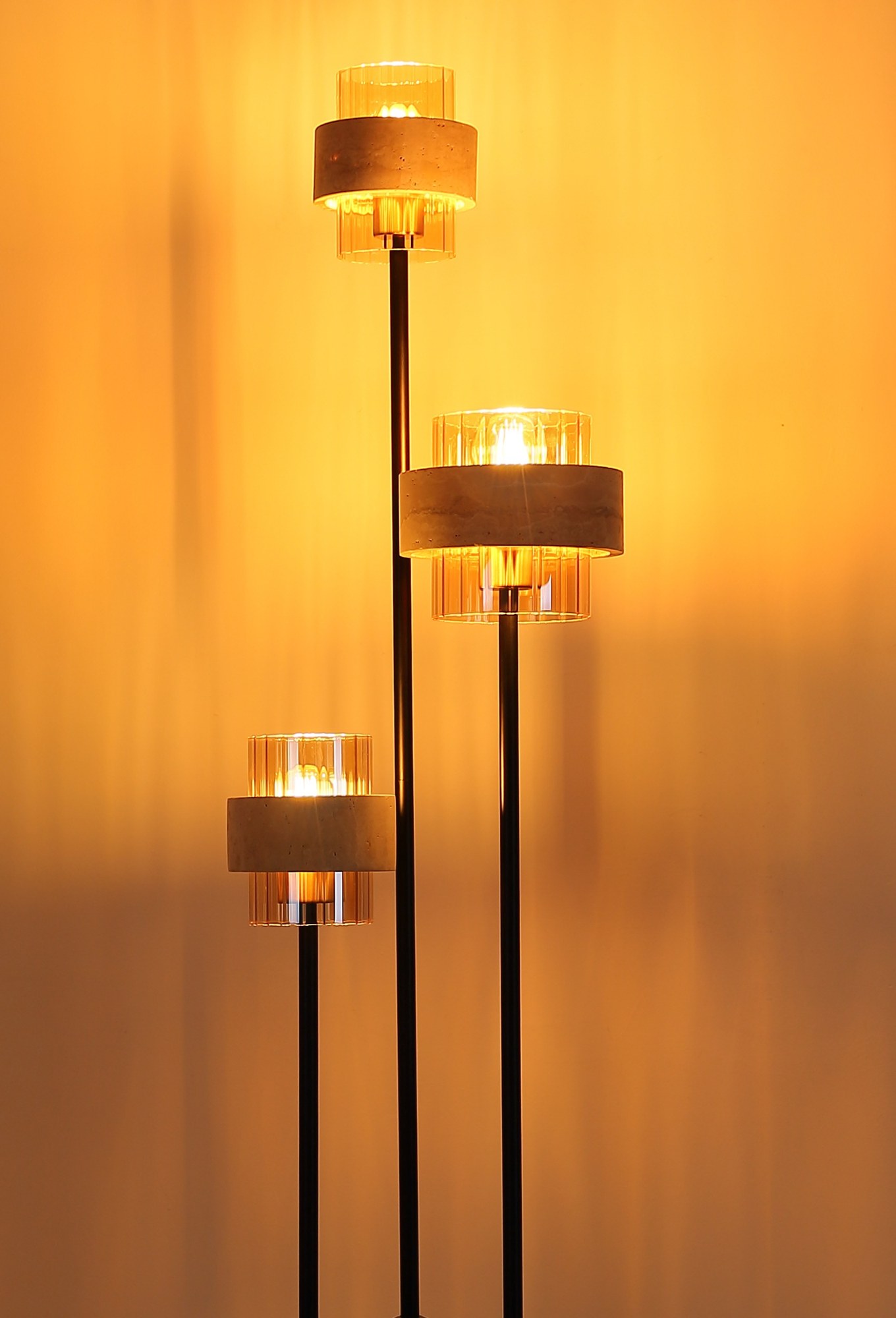 Lampadaire travertin et verre ambre, 3 lumières lampadaire travertin allumé, gros plan sur les trois abat-jours étagés