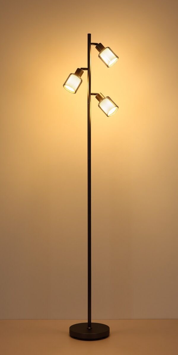 lampadaire verre rayé gunmetal allumé, lumière chaude sur le mur