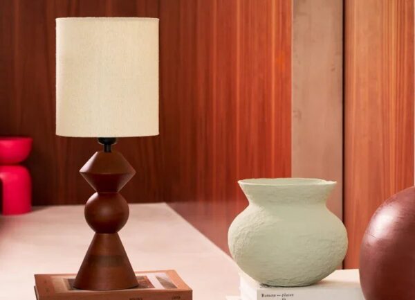 lampe à poser bois Tre Urban Nature Culture, posée sur une table basse en béton avec des livres et des vases