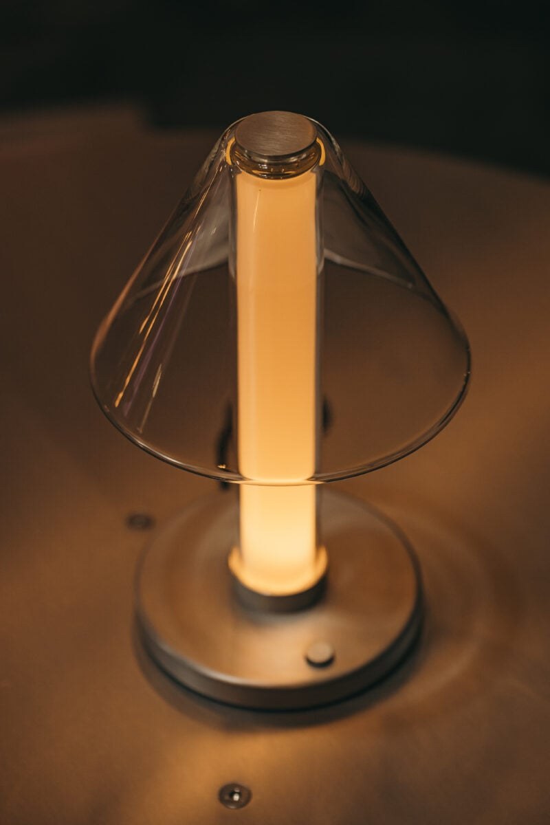Lampe à poser Fragile S cône Marset, allumée sur une table, vue de près