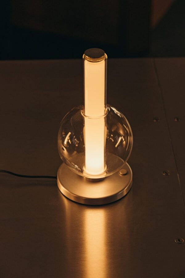 Lampe à poser Fragile S sphère Marset, allumée sur une table