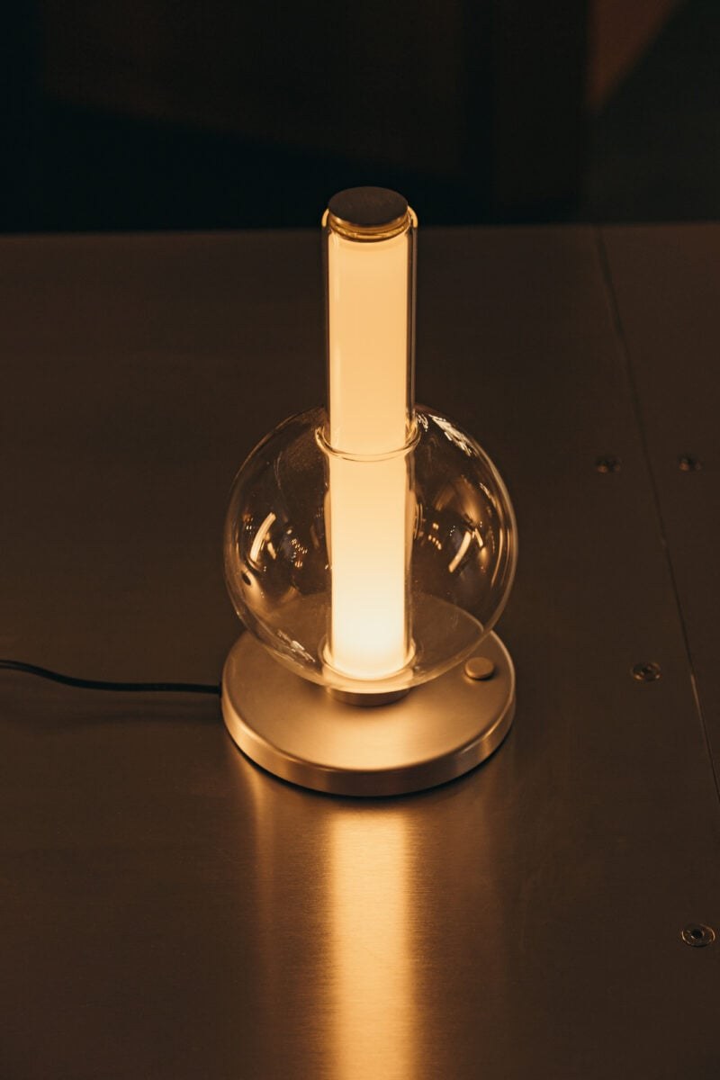 Lampe à poser Fragile S sphère Marset, allumée sur une table