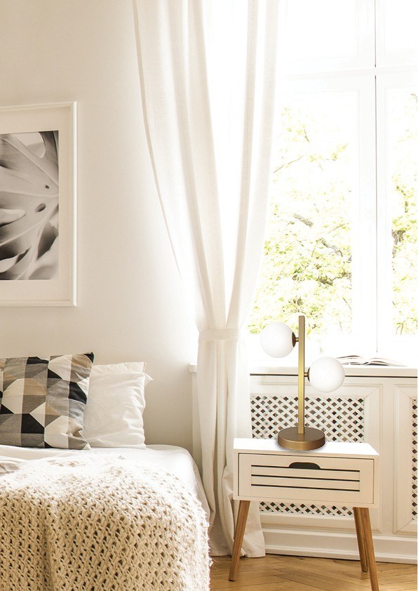 lampe à poser globes opale sur une table de chevet dans une chambre claire