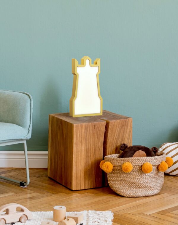 lampe à poser tour enfant jaune en bois posee dans une chambre d enfant