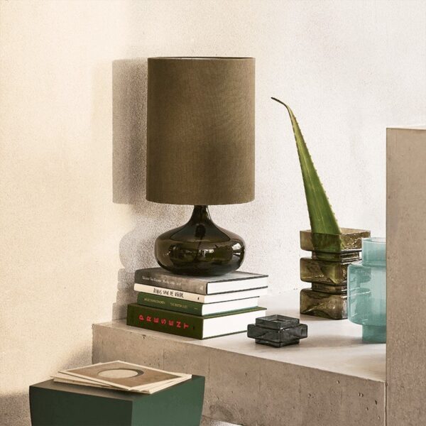 lampe à poser verre Luz Kalamata Urban Nature Culture, posée sur un muret en béton avec des livres