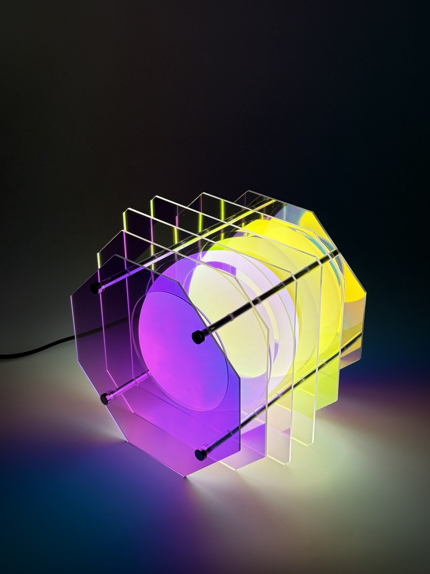 Lampe de table octogonale irisée Pavao Studio lampe de table octogonale irisée Pavao Studio, halo violet et jaune sur le mur