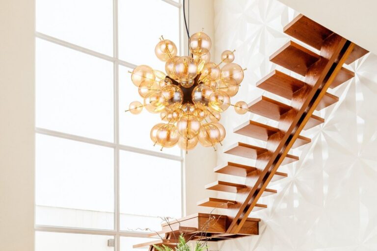 Lampe escalier : suspension grappe de boules de verre ambre au-dessus d'un escalier suspendu en bois