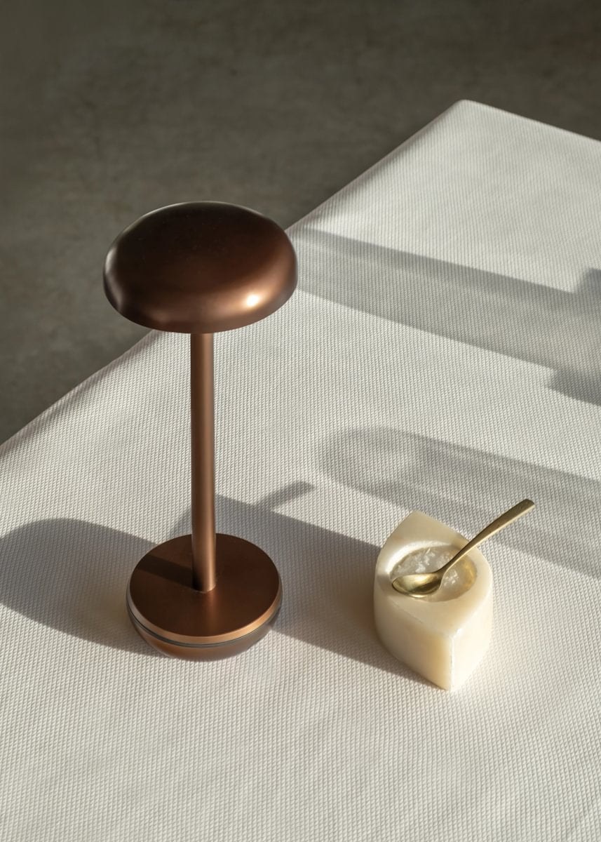 Lampe rechargeable Air par Humble, aluminium, 8 finitions lampe rechargeable Air Humble, finition Bronze sur une nappe