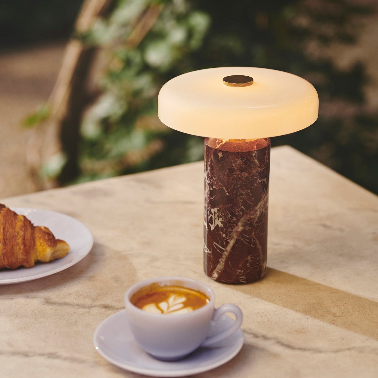 Lampe rechargeable Trip par Design by Us, marbre et verre lampe rechargeable Trip Design by Us, coloris Burgundy allumée près d'un café