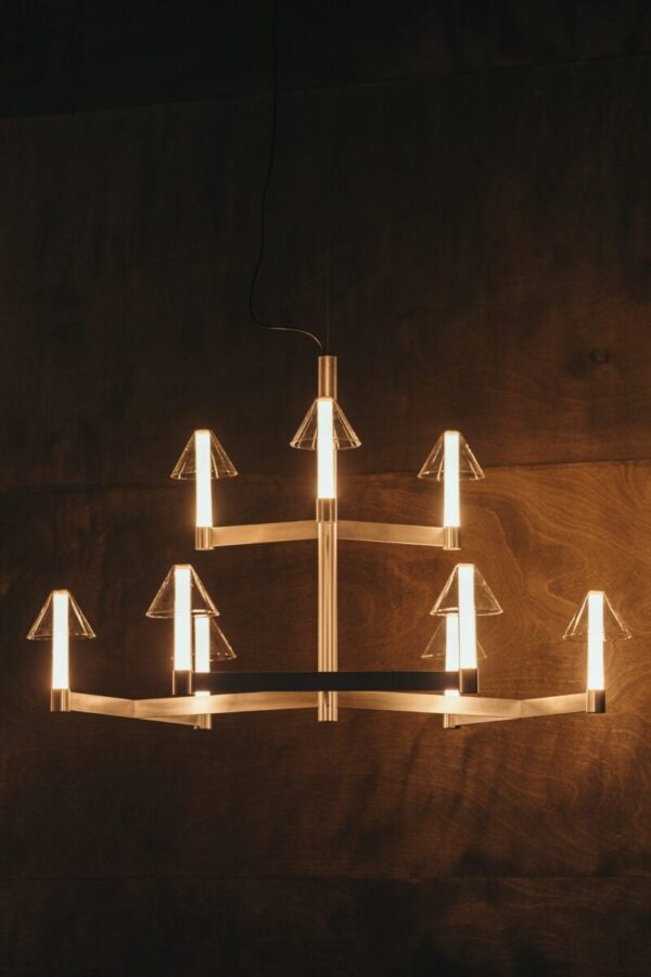 Lustre Fragile Marset cône CH9 allumé sur un mur en bois sombre