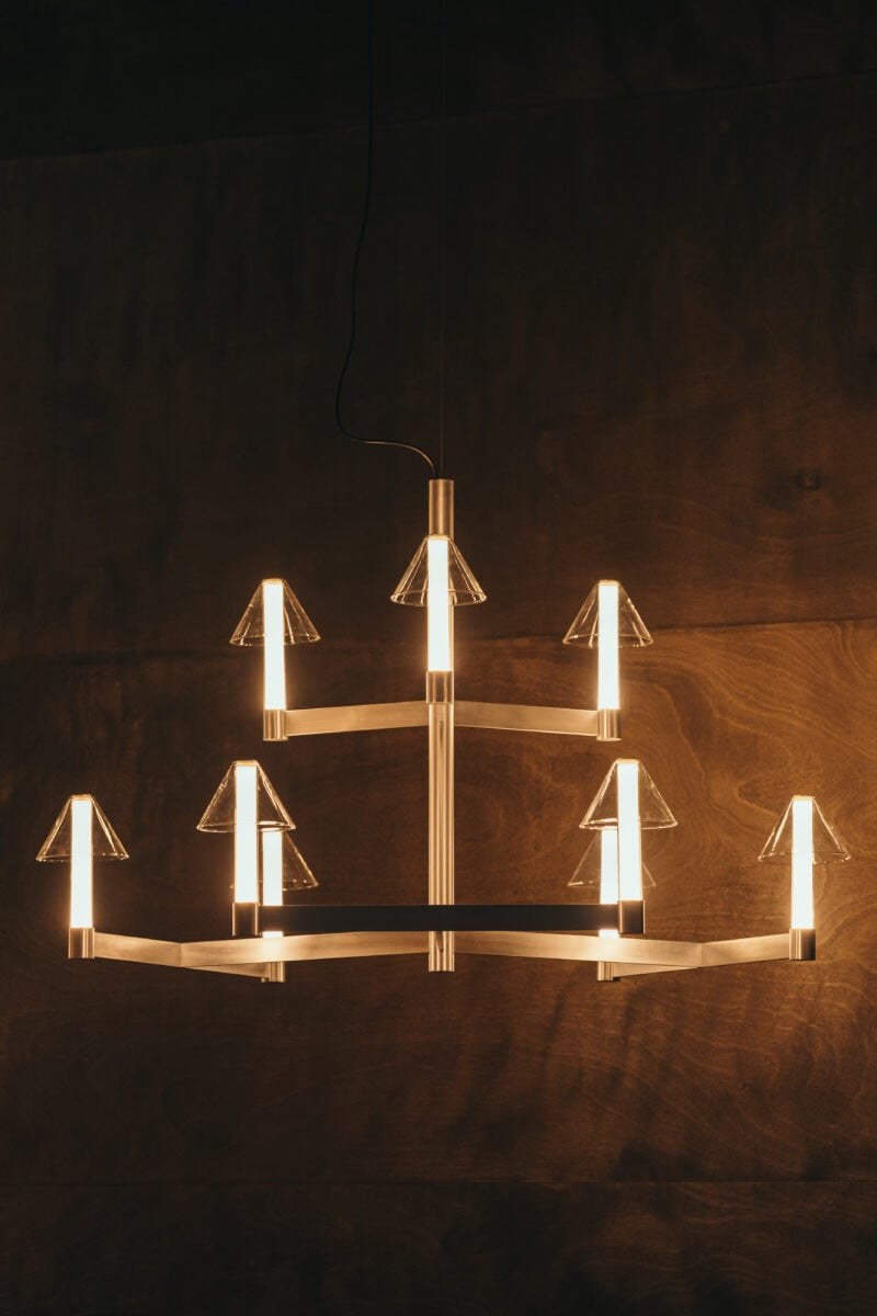 Lustre Fragile Marset cône CH9 allumé sur un mur en bois sombre