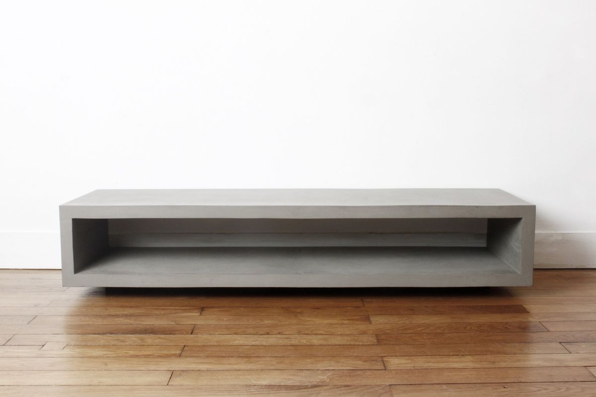Meuble TV béton : comment bien le choisir pour son salon ? Meuble TV béton monobloc de Lyon Béton posé sur un parquet, structure d'un seul bloc au style minimaliste