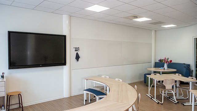 Mur d'écriture magnétique Sharp Wall par Chameleon, sans cadre mur d'écriture magnétique Sharp Wall Chameleon dans une salle de formation avec écran