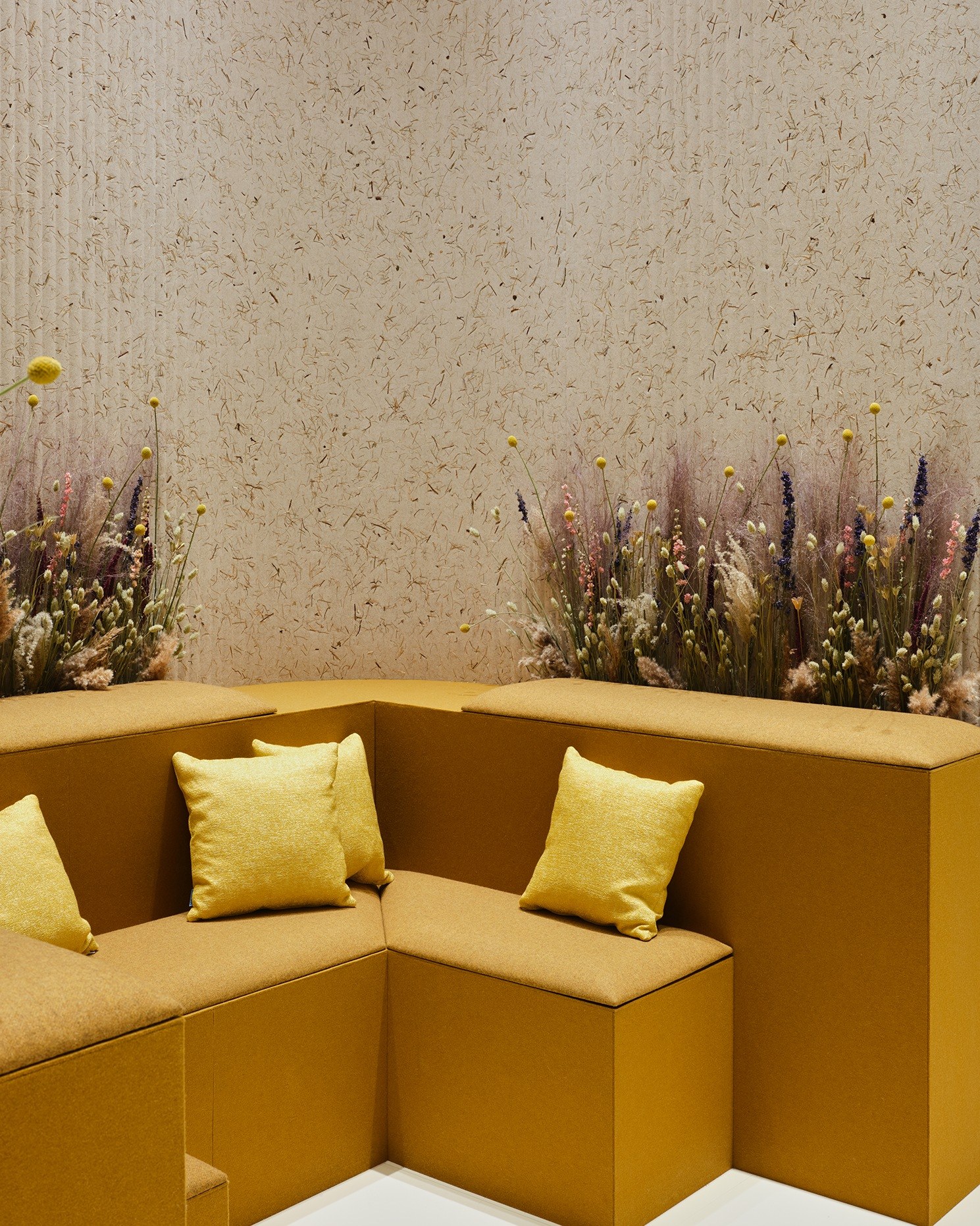 Panneau acoustique herbes naturelles Grass par Slalom, lin et foin panneau acoustique herbes naturelles Slalom Grass dans un angle avec banquette et coussins jaunes